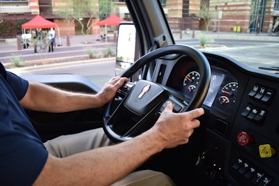 Man driving truck with hands on steering wheel