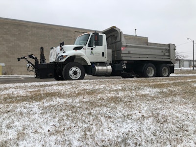 Truck parked next to grassy area with snow