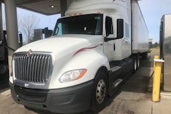 white semi truck parked getting fuel