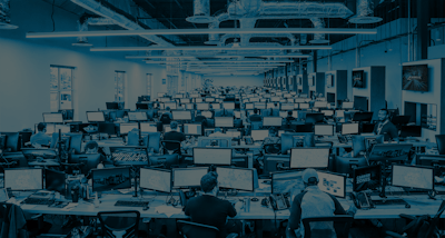 large office room with rows of desks and computers