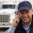 man on cellphone in front of semi truck