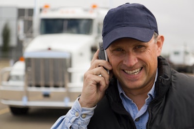 man on cellphone in front of semi truck