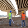 two construction workers working under bridge
