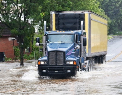 semi truck driving through flooded roadway