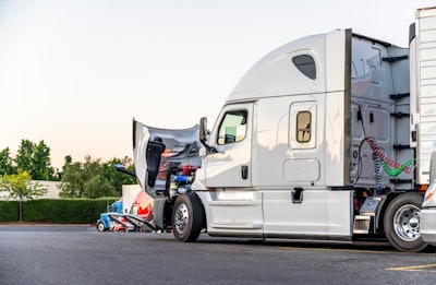 semi truck parked with hood up