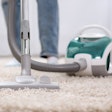 person using vacuum cleaner on carpet
