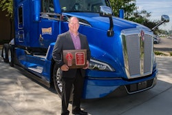 Scott Reed, Werner Enterprises senior vice president of equipment purchasing and maintenance, holds a plaque signifying the delivery of the first production Kenworth T680 Next Generation at the Kenworth plant in Chillicothe, Ohio.