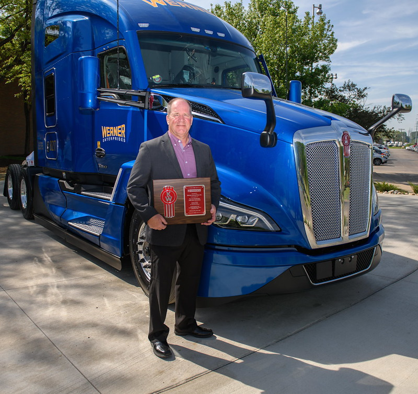 Scott Reed, Werner Enterprises senior vice president of equipment purchasing and maintenance, holds a plaque signifying the delivery of the first production Kenworth T680 Next Generation at the Kenworth plant in Chillicothe, Ohio.