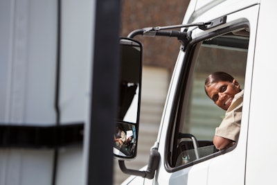 woman smiling out of drivers side window of truck