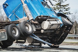 truck leaning on side at wreck site