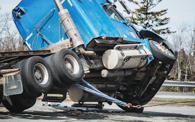 truck leaning on side at wreck site