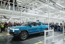 Rivian CEO RJ Scaringe is shown behind the wheel of the nation's first mass-produced electric pickup, the R1T.