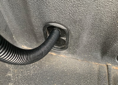 Since we get plenty of rain, I chose to run the gutter drain tube through the bed wall plug. Some installers just opt to drop it into the bed.