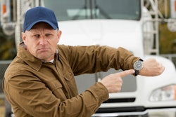 truck driver pointing to his watch