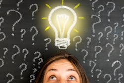 Woman looking up at a drawing of an illuminated light bulb