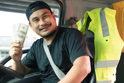 truck driver holding cash after getting paid