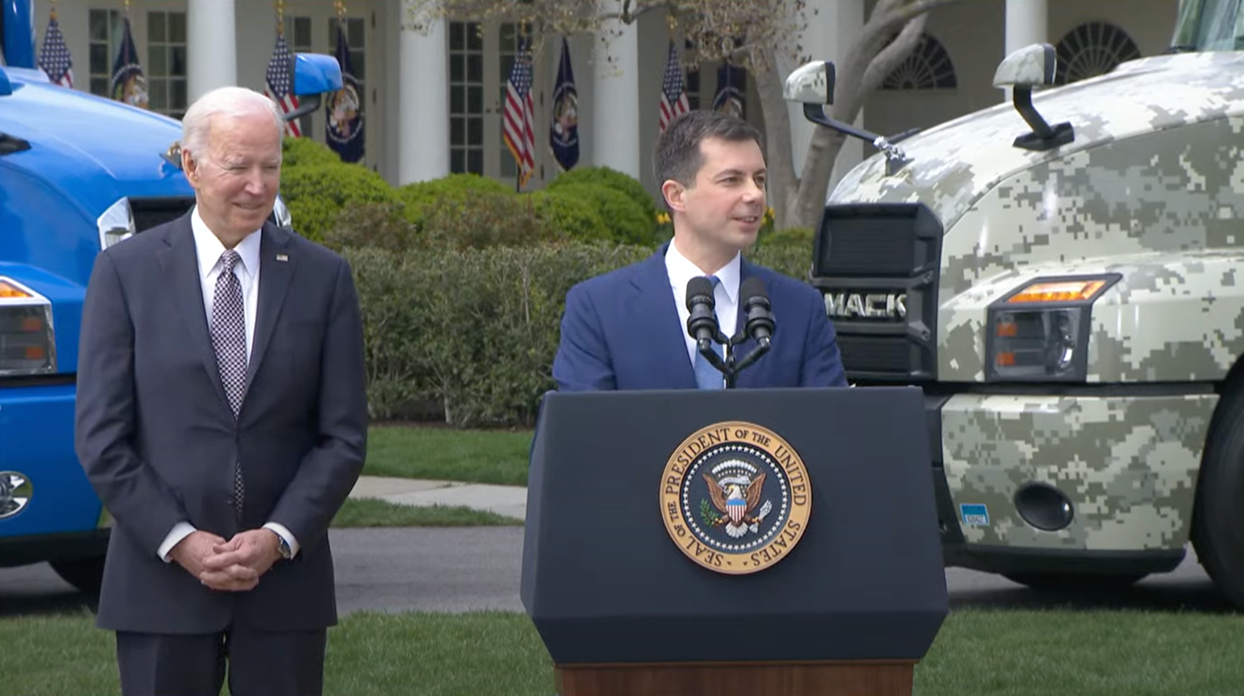 Transportation Secretary Pete Buttigieg and President Joe Biden in front of trucks