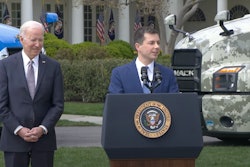 Transportation Secretary Pete Buttigieg and President Joe Biden in front of trucks