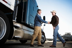 Customer shaking hands with truck sales rep.