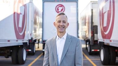 keith wilson ceo of titan freight standing in front of titan freight semi-trucks