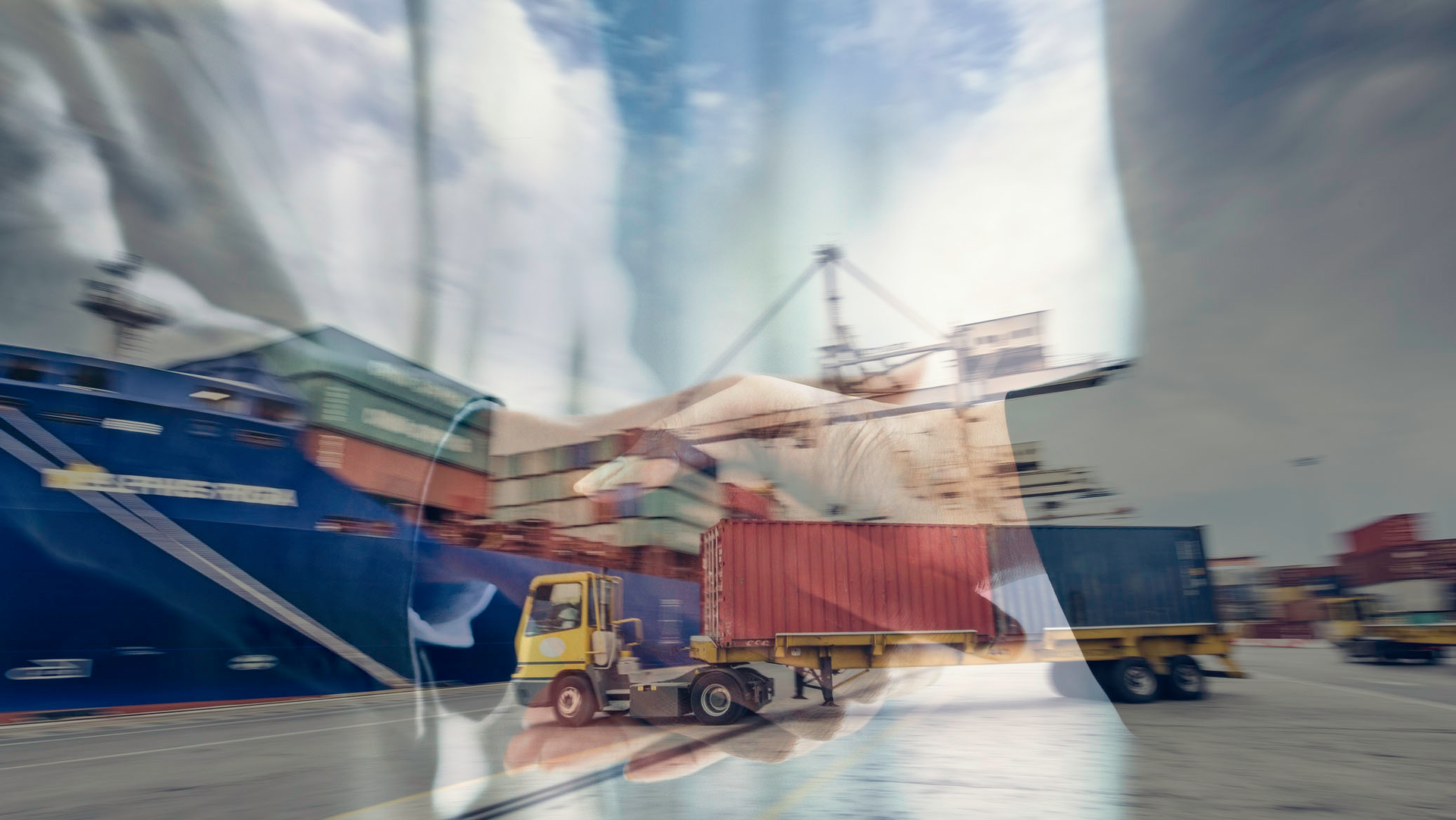 a truck moving a container towards a cargo ship with various shipping containers