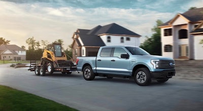 F-150 lightning towing a trailer with construction equipment