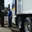 Driver fuels a truck at a diesel pump.