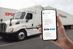 XPO Connect on a smart phone being held up in front of an XPO Logistics semi-truck