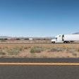 white semi-truck and train