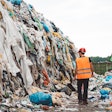 man walking through a landfill