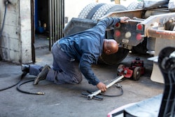 Man jacking up the rear of a semi