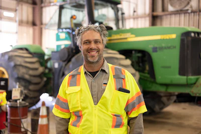 Technician of the year Robert Kesselring in shop with John Deere tractor in background