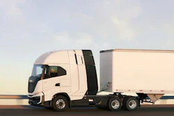 A white truck and trailer going down the road.