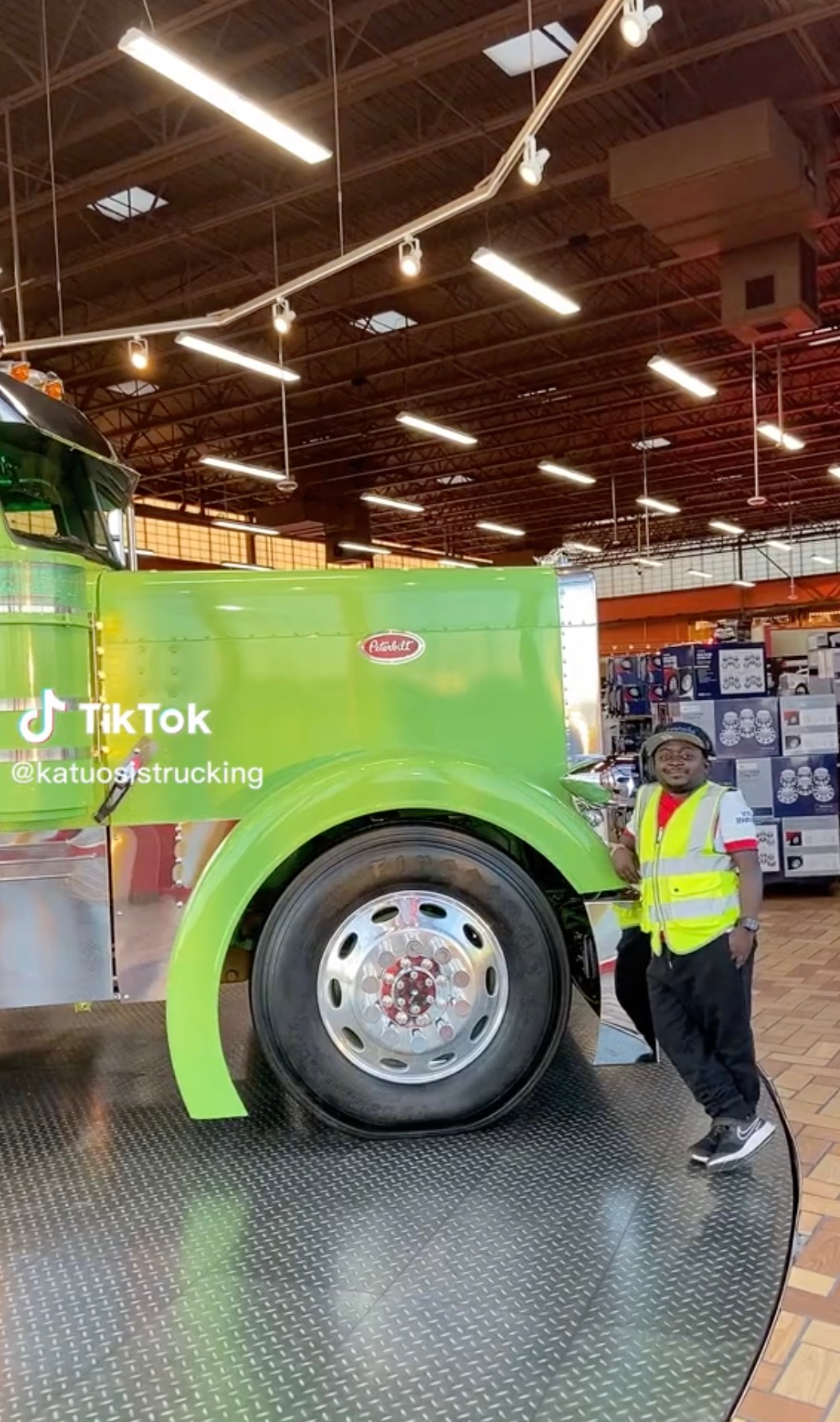 Joachim Wangui standing next to a lime green Peterbilt