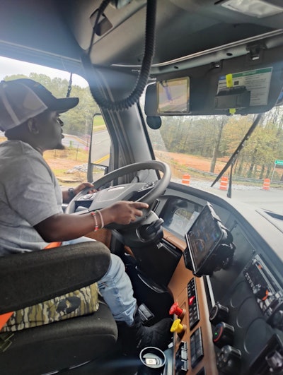 U.S. Xpress driver Joachim Wangui behind the wheel of a semi-truck