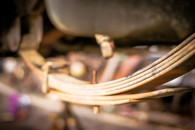 A leaf spring installed on a truck.