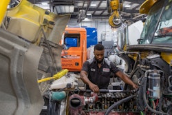 Technicians working on an engine in a truck shop