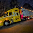 Brakebush Kenworth semi-truck at night with lights on