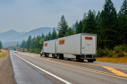 Yellow semi hauling dual pup trailers