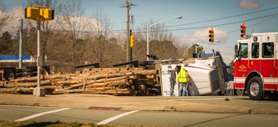 semi truck loaded with logs overturned