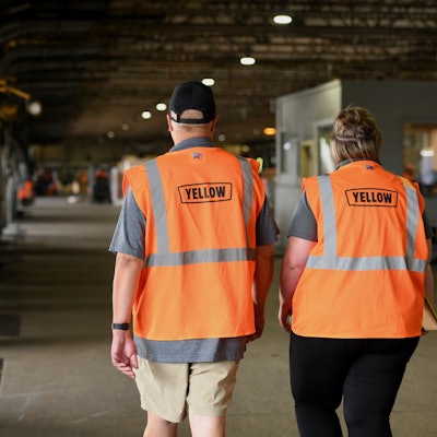 Yellow employees walking in a warehouse