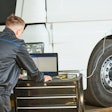 technician using a laptop on a semi repair