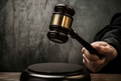 A person hitting a stand with a gavel