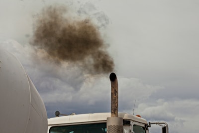 A cloud of dark exhaust floats from a truck exhaust pipe.