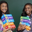 Two Girl Scouts with boxes of cookies
