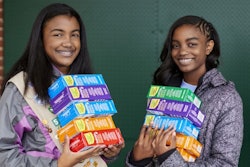 Two Girl Scouts with boxes of cookies