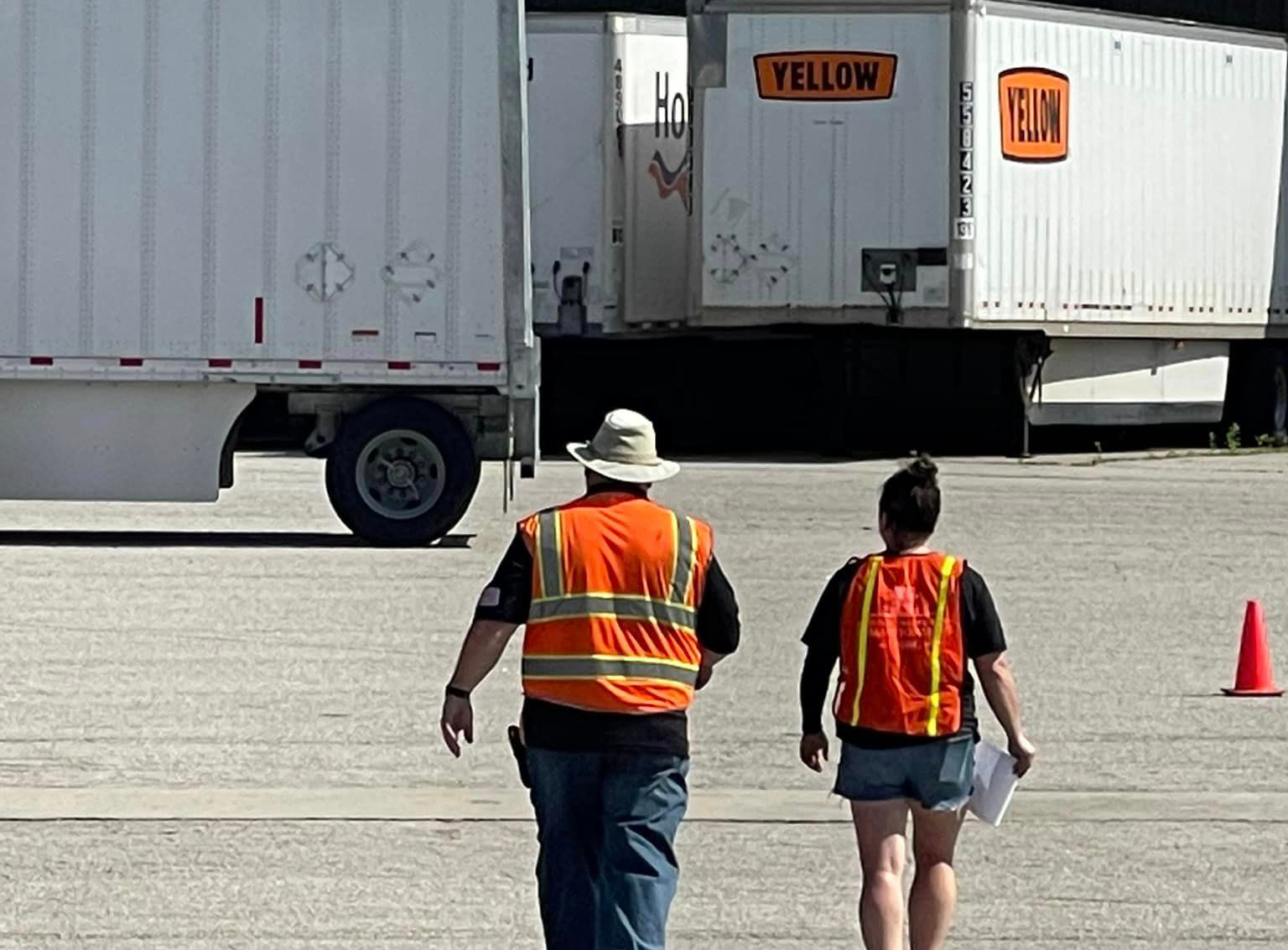 Yellow workers walking across parking lot
