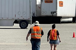 Yellow workers walking across parking lot
