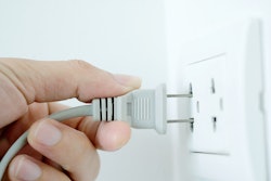 hand plugging into an outlet