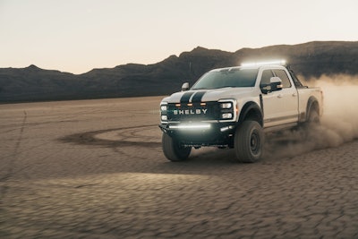 Shelby 2023 Ford F-250 Super Baja with lights kicking up dust in desert